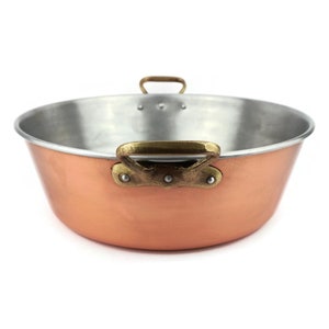 Puede incluir: Una olla de cobre con asas de latón. La olla tiene un revestimiento de plata y es redonda.