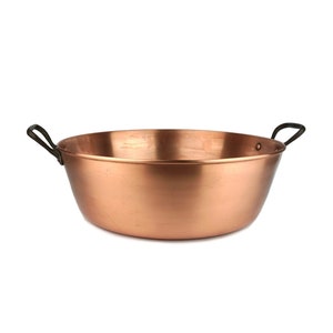 Puede incluir: Una olla grande de cobre con dos asas negras. La olla es redonda y tiene una superficie lisa y brillante.