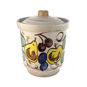 May include: White ceramic canister with a lid, featuring a hand-painted design of pears, grapes, and cherries in shades of yellow, green, blue, and red.