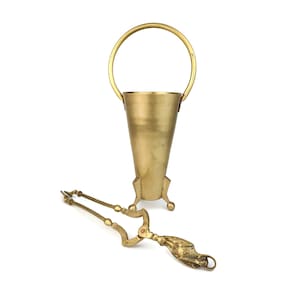 Könnte beinhalten: Vintage Eiswürfelbehälter aus Messing mit Griff und passender Zange. Der Eiswürfelbehälter ist konisch geformt und hat einen runden Griff. Die Zange hat dekorative Griffe.