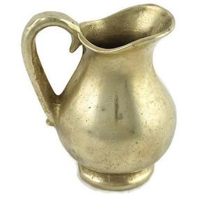 Könnte beinhalten: Ein kleiner, goldfarbener Metallkrug mit rundem Körper und einem gebogenen Henkel.