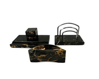 Pode incluir: Conjunto de organizador de mesa de mármore preto com veios dourados. O conjunto inclui um porta-canetas, um porta-cartas e uma caixa pequena.
