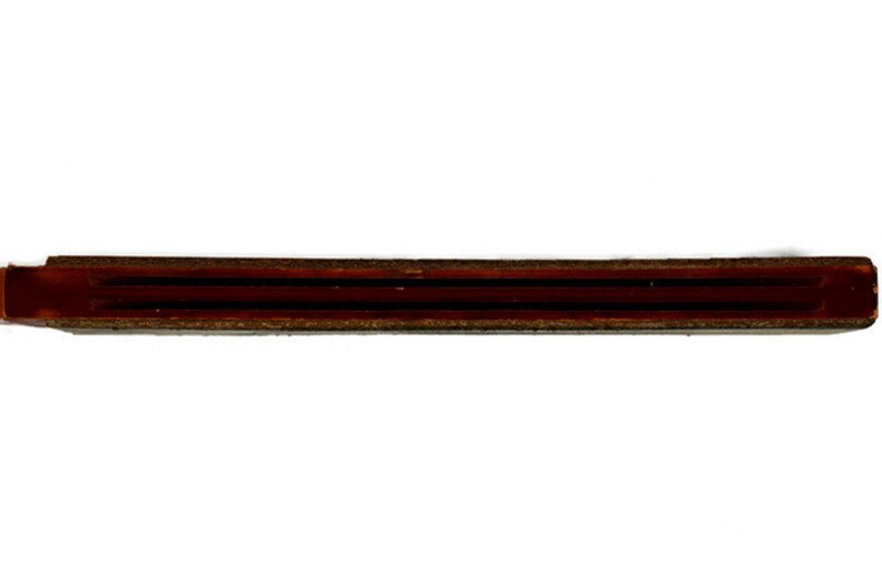 May include: A close-up of a brown wooden dowel rod with three grooves running along its length.