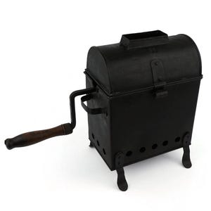 May include: A black metal antique popcorn popper with a wooden handle. The popper has a rectangular base with rounded corners and a hinged lid. The handle is attached to a crank on the side.