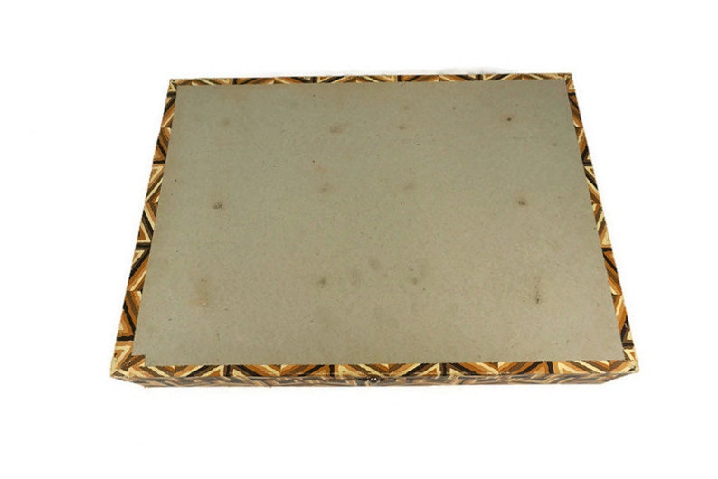 May include: A rectangular box with a brown, black and white geometric pattern on the lid. The box is made of wood and has a hinged lid.