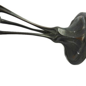 May include: A silver-toned metal base with an intricate design. The base has a wide, flat top and three curved legs that extend out from the center. The legs are decorated with a floral pattern.