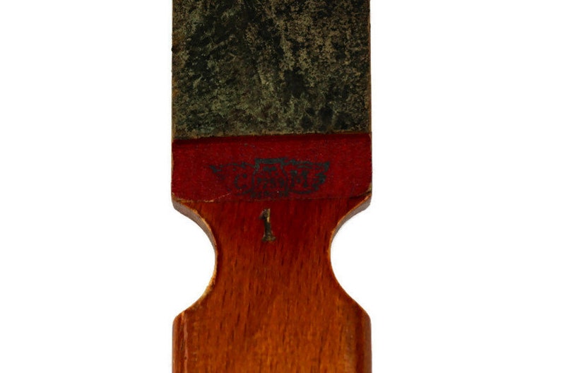 May include: A wooden sharpening tool with a red and green surface. The tool has a number "1" printed on it. The text "The Best" is printed on the red surface.
