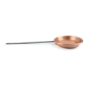 May include: A copper-colored frying pan with a long, dark metal handle. The pan has a round cooking surface and is designed for stovetop use. The handle extends horizontally from the pan's body.