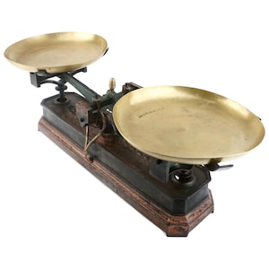 Peut inclure: Ancienne balance de pesée avec deux plateaux en laiton et une base verte foncée et marron. La balance présente un design classique, avec un bras central et un petit poids en laiton. Les plateaux sont ronds et peu profonds.