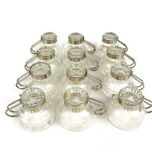 May include: Set of 12 clear glass cups with silver metal handles. The cups have a decorative pattern and are ideal for serving coffee, tea, or other beverages.