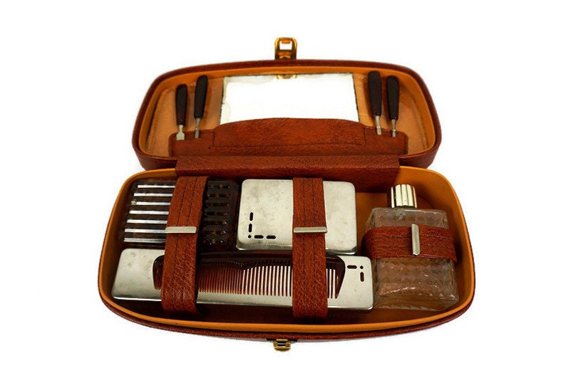 Vintage toiletry kit in leather travel case, on isolated gray