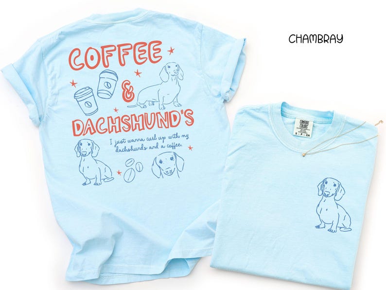 May include: Two light blue t-shirts. One has a dachshund graphic on the front and the text "Coffee & Dachshund's" with coffee cups and dachshund illustrations on the back. The other shirt has a dachshund graphic on the front.