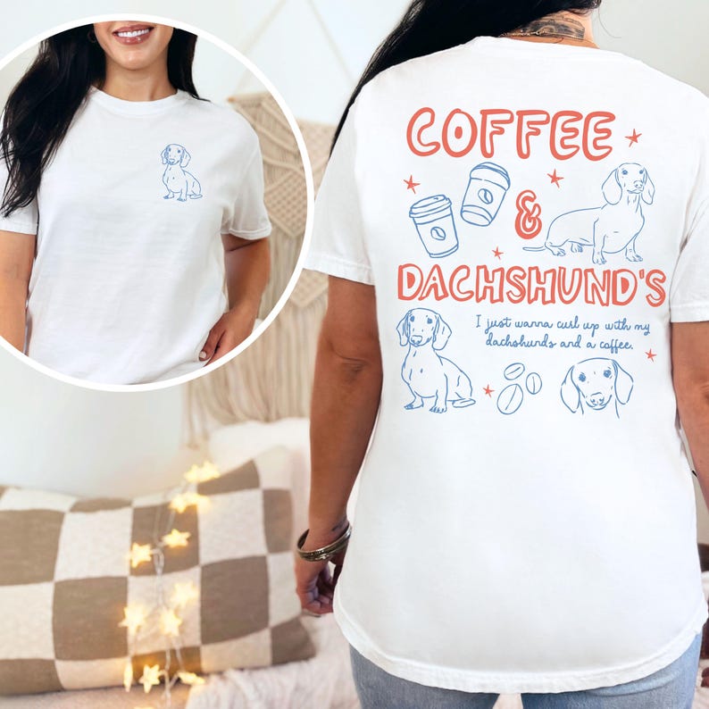 May include: White t-shirt with a blue dachshund graphic on the front and back. The back of the shirt features the words "Coffee & Dachshund's" with coffee cup and dog illustrations. The text "I just wanna curl up with my dachshunds and a coffee" is also on the back.