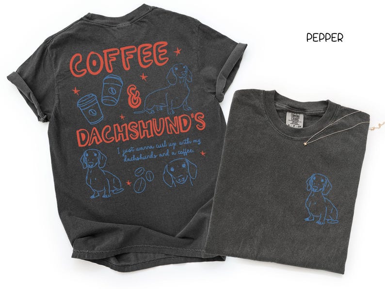 May include: Two dark gray t-shirts. One has the words "COFFEE & DACHSHUND'S" in red and blue, with dachshund and coffee cup graphics. The other shirt has a small dachshund graphic on the pocket.