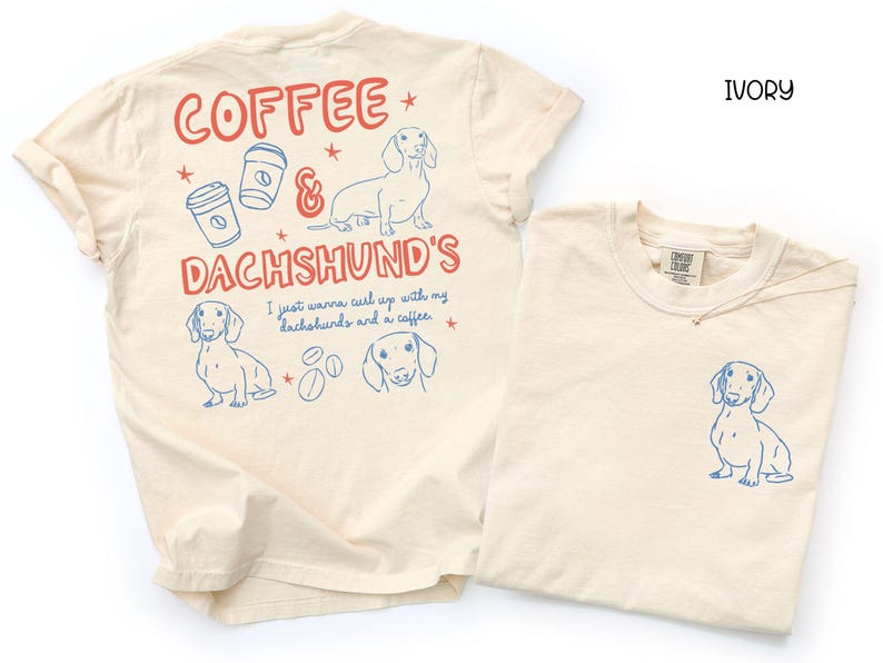 May include: Ivory-colored t-shirts with blue and red graphics. One shirt features a dachshund illustration on the front and a larger design on the back with the text "Coffee & Dachshund's". The other shirt has a dachshund illustration on the front.