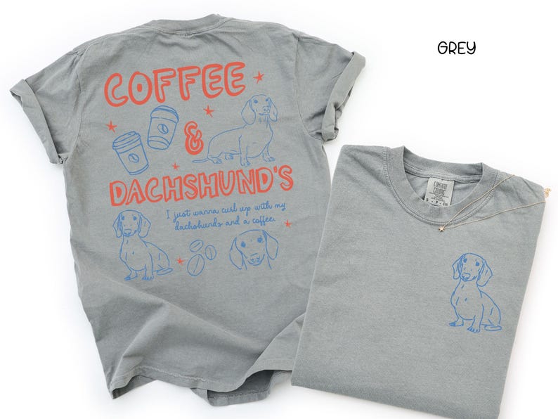 May include: Two grey t-shirts. One displays the text "COFFEE & DACHSHUND'S" with dachshund and coffee cup illustrations. The other shirt has a dachshund illustration. Both shirts have blue and red designs.