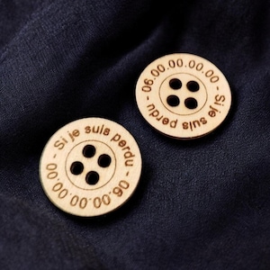 Peut inclure: Deux boutons en bois avec le texte "Si je suis perdu - 00.00.00.00.00 -" et "Si je suis perdu - 00.00.00.00.00 -" gravés dessus.