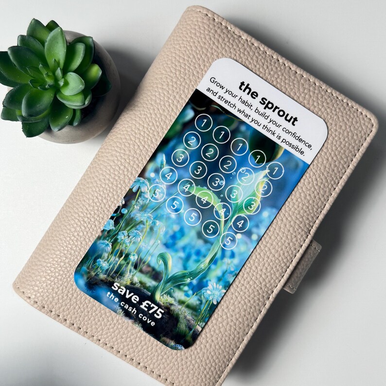 Puede incluir: Una cartera de cuero beige con una tarjeta que dice "the sprout" y "save &pound;75". La tarjeta tiene un dise&ntilde;o floral con n&uacute;meros del 1 al 5 en c&iacute;rculos. Una peque&ntilde;a planta suculenta verde en una maceta gris est&aacute; en el fondo.