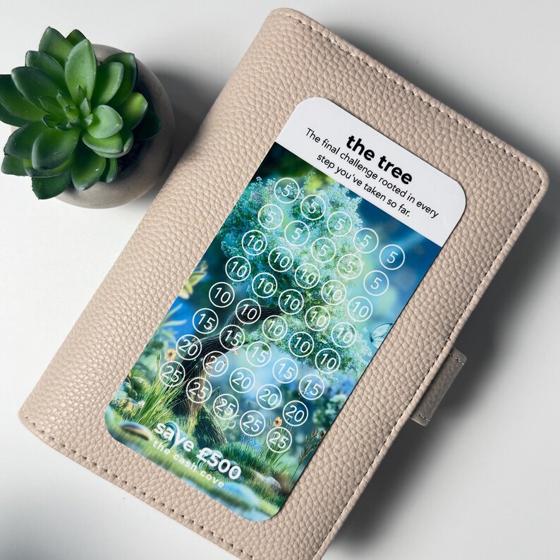 Puede incluir: Una cartera de cuero beige claro con una tarjeta de desaf&iacute;o de ahorro con un dise&ntilde;o de &aacute;rbol. La tarjeta tiene c&iacute;rculos con n&uacute;meros del 5 al 25 y el texto "save &pound;500". Una peque&ntilde;a planta suculenta en una maceta gris est&aacute; en el fondo.