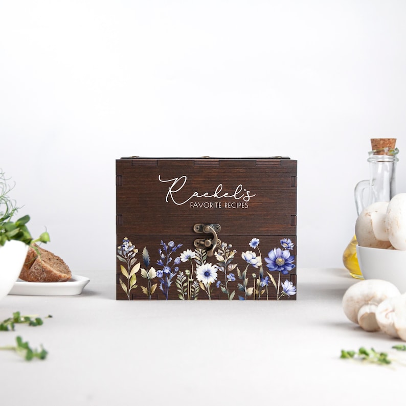 May include: A wooden recipe box with a floral design and the text "Rachel's Favorite Recipes" on the lid.