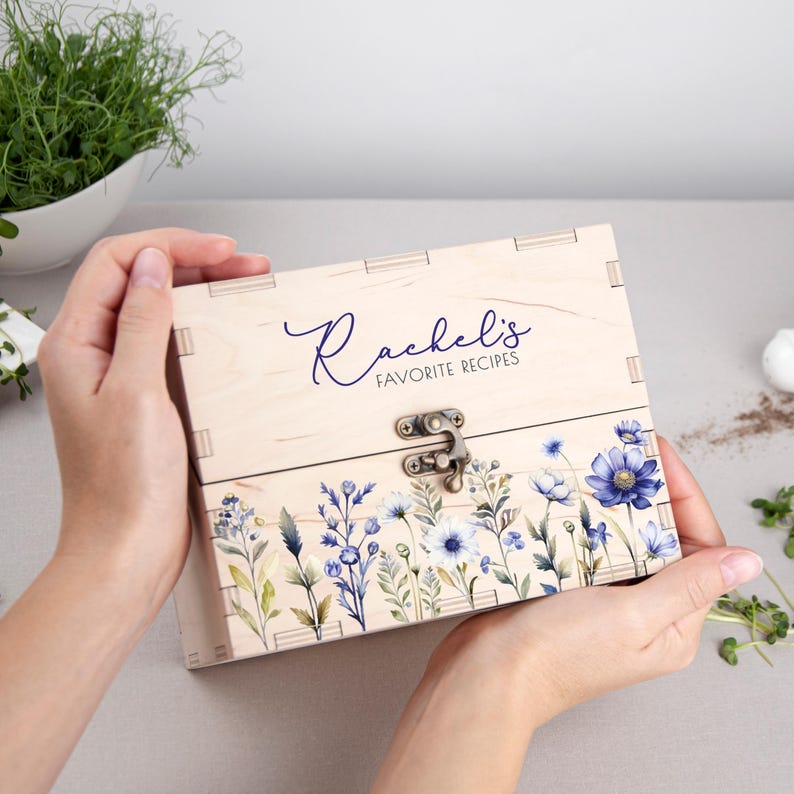 May include: A wooden recipe box with a floral design and the text "Rachel's Favorite Recipes" on the front.