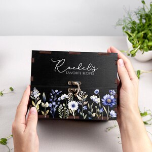 May include: Black wooden recipe box with a floral design and the text "Rachel's Favorite Recipes".