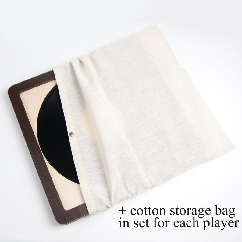 May include: A wooden record storage box with a black vinyl record inside. A white cotton storage bag is included in the set.