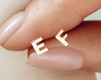 Puede incluir: Un par de pendientes de oro con las iniciales "E" y "F".