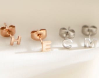 Puede incluir: Cuatro pares de pendientes de iniciales en oro, oro rosa y plata. Los pendientes tienen forma de las letras R, E, H, y C, y M.