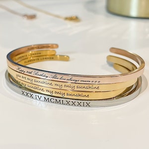 Engraved gold, silver and rose gold bracelets with different fonts.