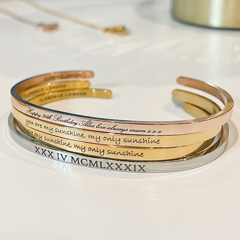 Engraved gold, silver and rose gold bracelets with different fonts.