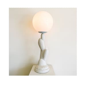 May include: A white ceramic table lamp shaped like a cactus with a large white globe shade.