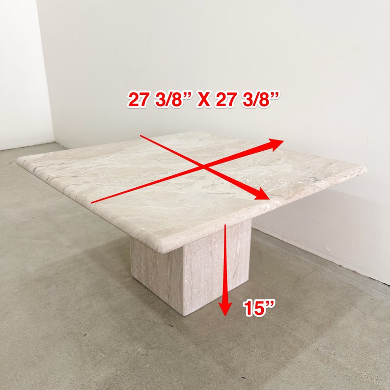 May include: A square travertine coffee table with a 27 3/8" x 27 3/8" top and a 15" high base.