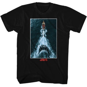 May include: Black t-shirt with a graphic of a shark's mouth with a boat in the background. The text "JAWS" is printed below the image.