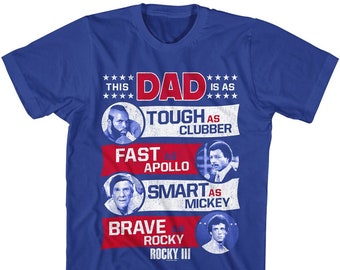 May include: Blue t-shirt with a graphic of a collage of characters from the movie Rocky. The text reads "This Dad is as Tough as Clubber, Fast as Apollo, Smart as Mickey, Brave as Rocky, Rocky III."