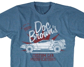 May include: A blue t-shirt featuring a white and red graphic of a DeLorean time machine and the text "Doc's Brown's Custom Car Modifications".