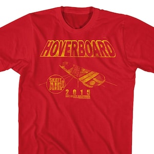 May include: Red t-shirt with a yellow graphic of a hoverboard and the text "Hoverboard Skate Air! 2015 Hill Valley California"