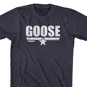 May include: A navy blue t-shirt with a white distressed graphic of the words "GOOSE" and the "Top Gun" logo.