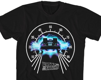 Könnte beinhalten: Schwarzes T-Shirt mit einem weißen Motiv eines DeLorean, der durch einen blauen und violetten Lichtschweif rast. Das Motiv ist ein Tachometer mit dem Text "Zurück in die Zukunft" darunter.
