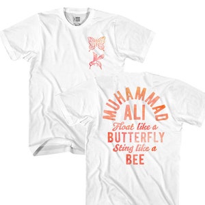 May include: White t-shirt with a red and orange watercolor design that says "Muhammad Ali Float like a Butterfly Sting like a Bee". The front of the shirt has a small butterfly and bee design.
