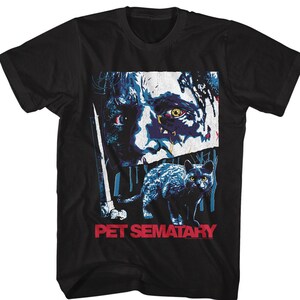 May include: Black t-shirt with a graphic print of a creepy face and a black cat. The text "Pet Sematary" is printed in red on the bottom of the shirt.