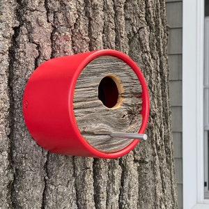 Unique stylish architectural designed wall mounted birdhouse gives birds a cozy home in vibrant poppy red color. The juxtaposition of salvaged 100-year-old vintage barn wood capping a modern angled vinyl tube adds functional art to any yard or garden