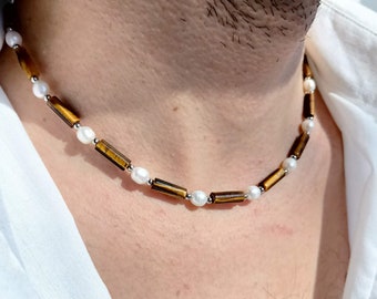 May include: A brown and white beaded necklace with tiger's eye beads and white pearls.