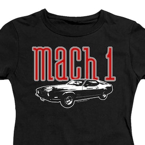 May include: Black t-shirt with a white silhouette of a classic car and the text "mach 1" in red.