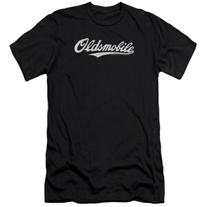Pu&ograve; includere: Maglietta nera con un logo "Oldsmobile" bianco in un font da baseball vintage.