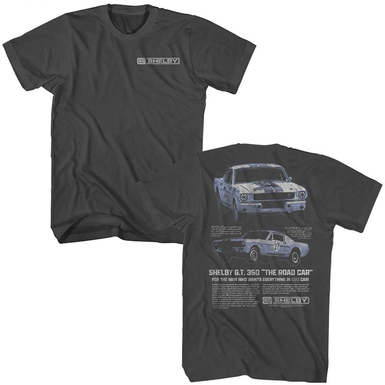 Op de afbeelding: Een donkergrijs T-shirt met een vintage afbeelding van een blauwe Shelby G.T. 350 auto. De tekst "SHELBY G.T. 350 "THE ROAD CAR" FOR THE MAN WHO WANTS EVERYTHING IN HIS CAR" staat op het shirt gedrukt.
