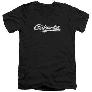 Pu&ograve; includere: Maglietta nera a collo a V con un logo "Oldsmobile" bianco in stile vintage.