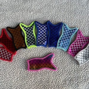 Puede incluir: Surtido de nueve enfriadores de latas con forma de cola de sirena en varios colores, incluyendo rojo, naranja, verde, azul y plateado. Los enfriadores están hechos de neopreno y tienen un patrón de escamas.