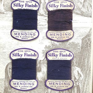 Puede incluir: Cuatro carretes de hilo de seda fina para coser, en tonos azul marino y morado oscuro. Cada carrete tiene una etiqueta que dice "Silky Finish" y "Mending Silk & Artificial Silk Hosiery", fabricado en Inglaterra.