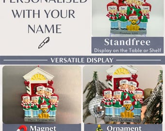 Könnte beinhalten: Ein personalisierbarer Weihnachtsschmuck mit einer sechsköpfigen Familie und einem Hund vor einer Hausfassade. Die Figuren tragen rote Mützen und grüne Pullover. Der Sockel ist mit Namen und dem Text Merry Christmas 2025 oder 2026 beschriftet.